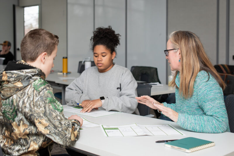 At a bootcamp, attendees work with a coach to develop their business model canvas.