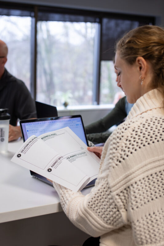 Entrepreneurs collaborating with a coach in a startup workspace
